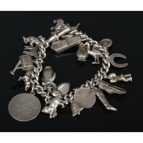 331 - An old curb silver charm bracelet, containing several dog charms, 1918 three pence piece, watering c... 