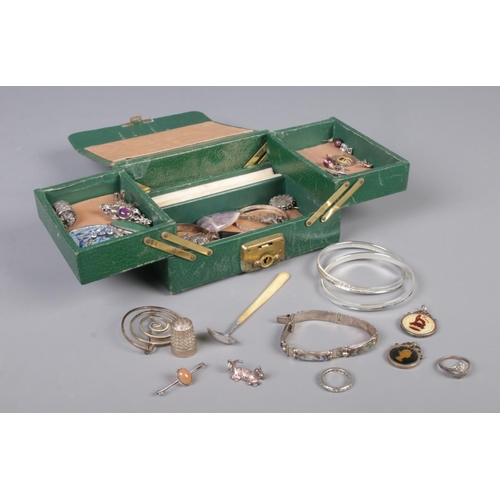 334 - A green leather cantilever jewellery box, containing a collection of silver and white metal oddments... 