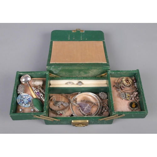 334 - A green leather cantilever jewellery box, containing a collection of silver and white metal oddments... 