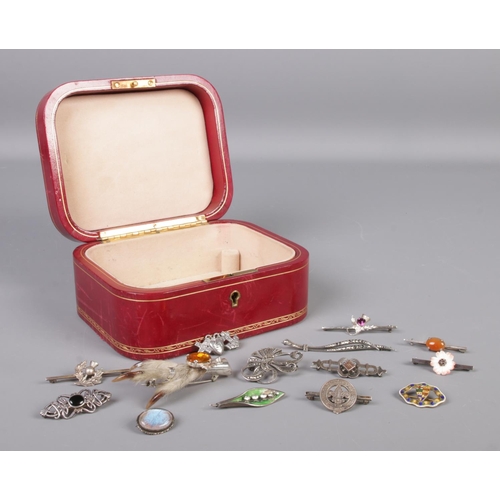 335 - An L. Mannelli red leather jewellery box containing fourteen vintage and Victorian silver brooches, ... 