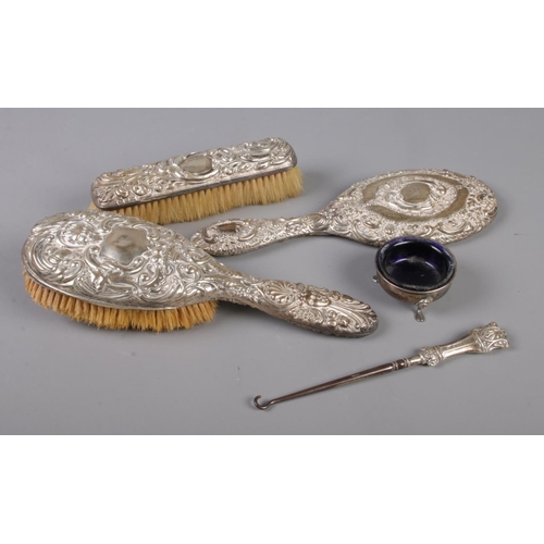 371 - A collection of silver and silver mounted items. Includes hand mirror, two brushes, button hook and ... 