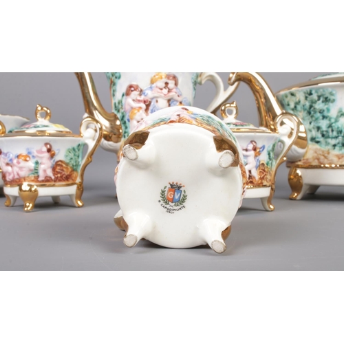 1 - A GV Capodimonte tea service featuring gilt edging and decorated with cherubs. Comprising of cups, s... 