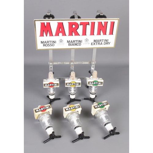 111 - A Martini optics bottle holder wall mount rack with three spare optics.