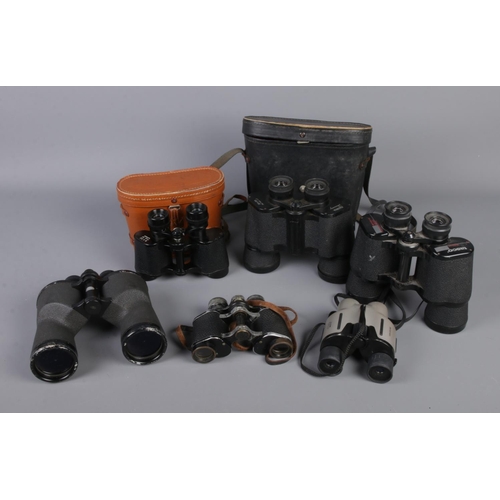 116 - A box of binoculars including Tasco, H.C.S De-Luxe, Longchamp, Halina, etc.