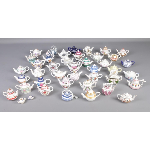 174 - A large collection of Porcelain Art miniature teapots.