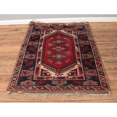 212 - A Turkish Dosemealti wool rug featuring central red medallion and indigo border. Approx. dimensions ... 