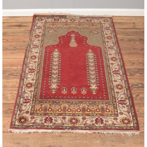 214 - A ground wool prayer rug featuring floral motifs.