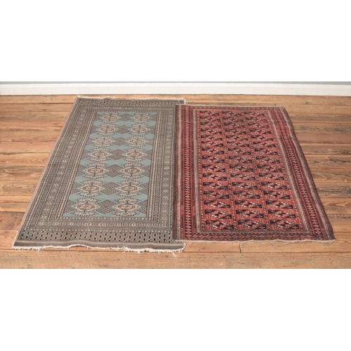 215 - Two ground wool fringed rugs including blue geometric example.