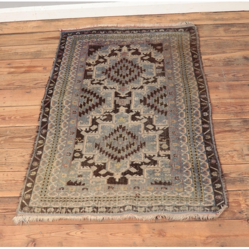 218 - A ground wool, fringed rug featuring geometric motifs.