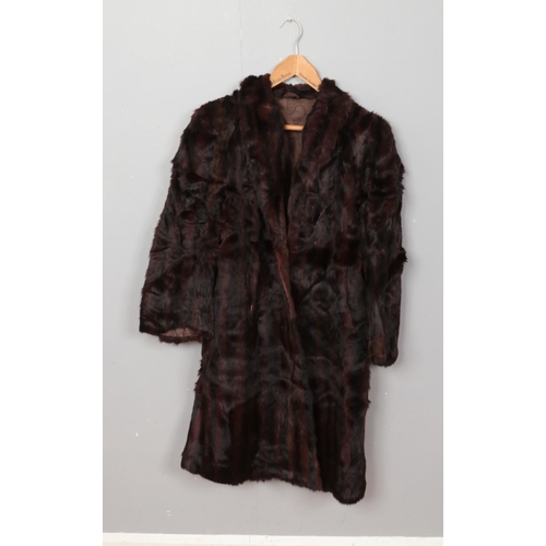 223 - A women's fur coat featuring hand sewn quilted interior.