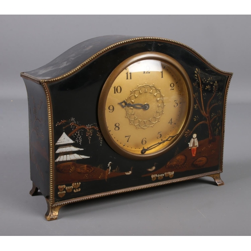 68 - A lacquered mantel clock with chinoiserie decoration and gilt metal mounts.