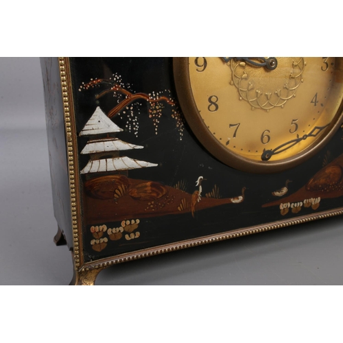 68 - A lacquered mantel clock with chinoiserie decoration and gilt metal mounts.