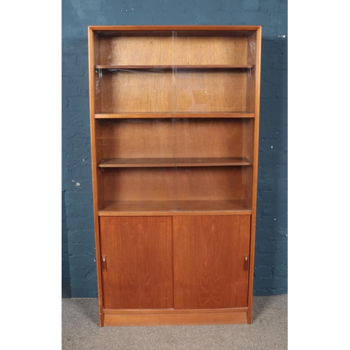 446 - A teak sliding front bookcase by Herbert E Gibbs no 6444 917.

Hx174cm
Wx91cm
Dx28cm