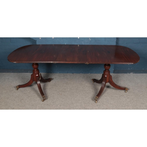 947 - A 20th century Regency style mahogany twin pedestal dining table, on turned columns with tripod spla... 