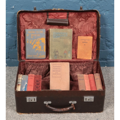 473 - A vintage suitcase containing an assortment of antique and vintage books. To include 'Ivanda A Tale ... 