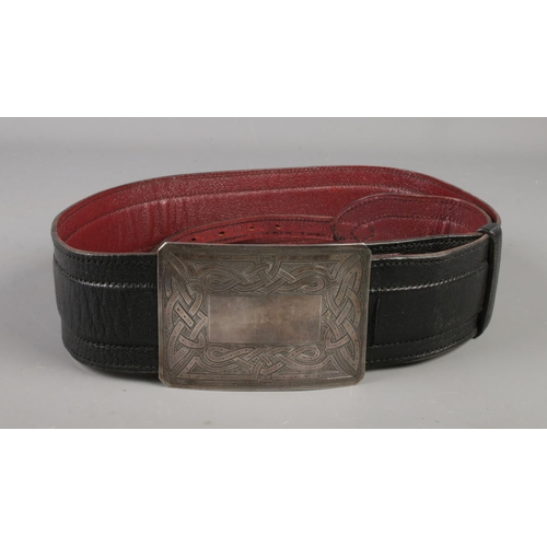 107 - A kilt belt with silver Celtic style buckle. Buckle stamped Sterling, Scotland.