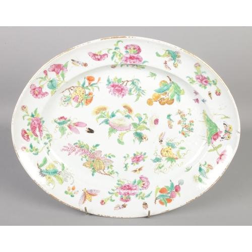 115 - A large hand painted Cantonese dish. Decorated with flower and insects. (36cm x 29cm)