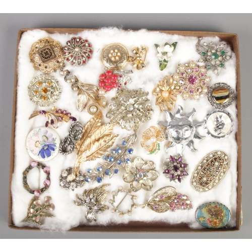 123 - A tray of costume jewellery brooches and scarf clips. Includes locket example, paste set etc.