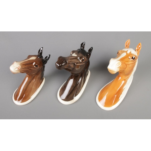 125 - A trio of Beswick horse wall plaques; Palomino 1384, Hunter 1382 and Arab 1385.