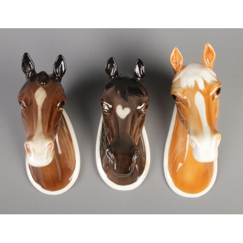 125 - A trio of Beswick horse wall plaques; Palomino 1384, Hunter 1382 and Arab 1385.