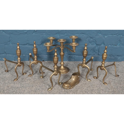 186 - A small collection of brassware. Includes fire dogs, candelabra, etc.