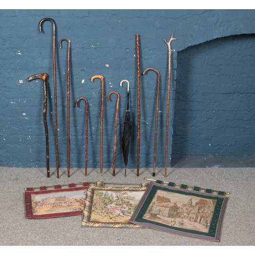 271 - A bundle of walking sticks and shepherds crooks along with three wall banners.