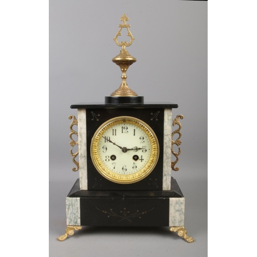 5 - An ornate French slate 8 day mantel clock with brass mount decoration, raised on four brass claw fee... 