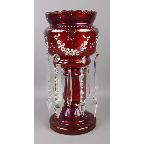 65 - A Bohemian ruby glass lustre with clear glass droplets and gilt and floral detailing. 32cm high.