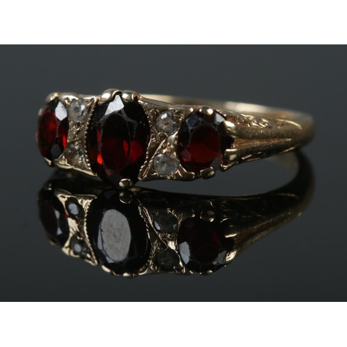 343 - A 9ct gold garnet and clear stone ring. Size L 1/2. 3.45g.