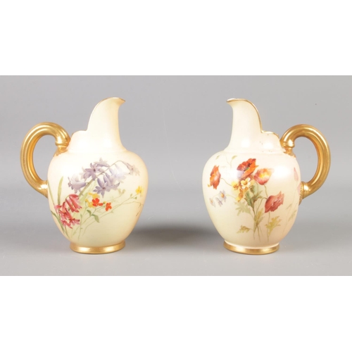 370 - A pair of Royal Worcester blushware jugs decorated with poppies, bluebells and gilt handles. 13cm ta... 