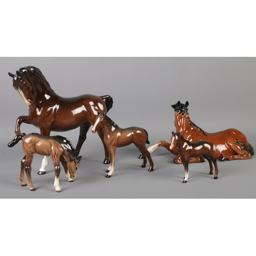 413 - Five Beswick ceramic horses, including sitting, prancing and foal examples.