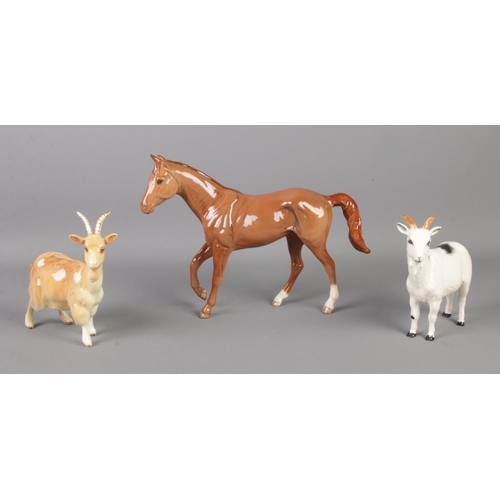 414 - A Royal Doulton ceramic horse, together with two goats; Royal Doulton and Beswick examples.