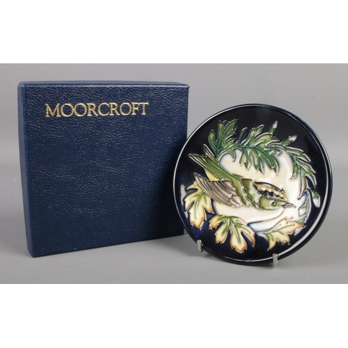 418 - A boxed Moorcroft dish decorated in the Inglewood pattern by Philip Gibson. 12cm diameter.