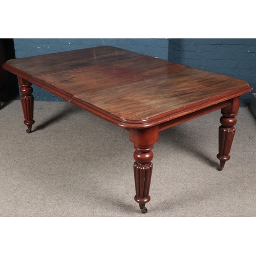 425 - A Victorian carved mahogany wind out dining table. (72cm x 124cm x 182cm)