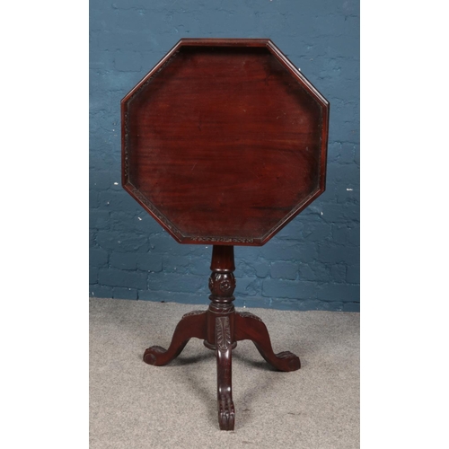 427 - A carved mahogany tripod table with fretwork gallery top and paw feet. Diameter of top 58cm.