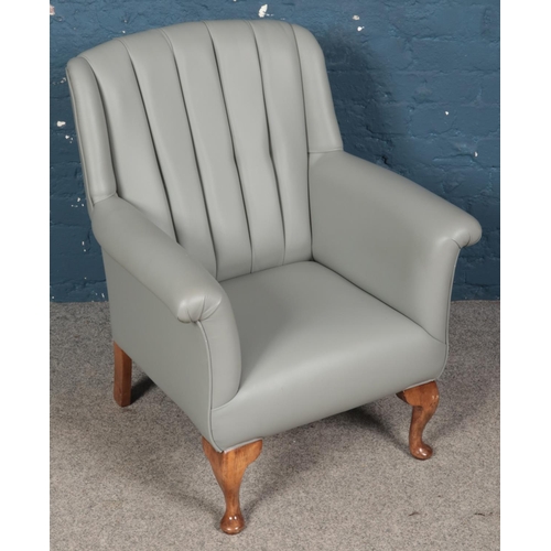 430 - A grey leatherette and studded armchair with mahogany legs.