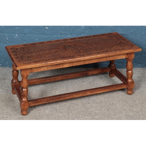 440 - A carved oak coffee table with central motif depicting St John's Church, Wales and floral border. (4... 