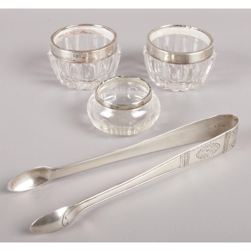 283 - A pair of early 20th century Swedish silver sugar tongs along with three silver rimmed glass jars.