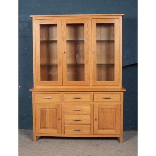 355 - A modern oak cabinet with illuminated top and glass shelving. Height 201cm Width 147cm Depth 46cm