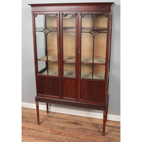 345 - A carved mahogany astragal glazed display cabinet. Raised on slender tapering legs. (175cm x 106cm)