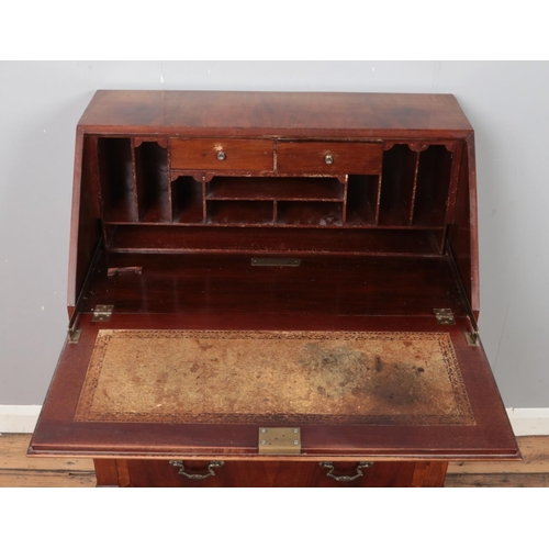 347 - A carved mahogany bureau raised on ball and claw feet with leather inset interior. (102cm x 75cm)