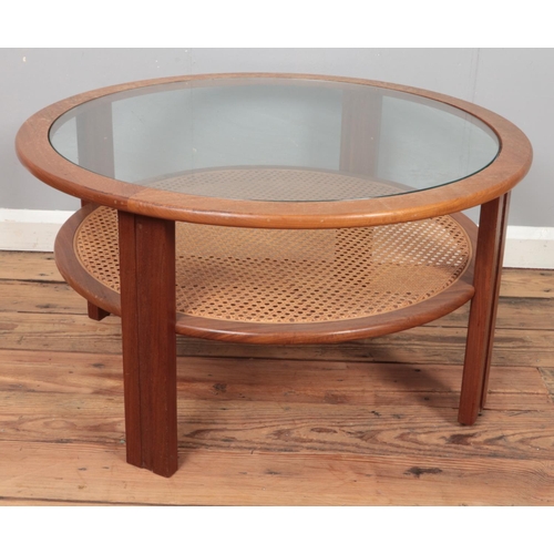 354 - A mid century teak circular coffee table with glass inset top and bergère lower tier. Diameter (82cm... 