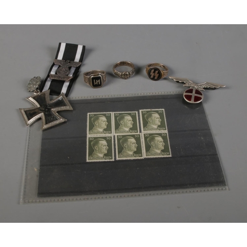 104 - A collection of replica German military items including rings, medals, stamps and  Norway cap badge.