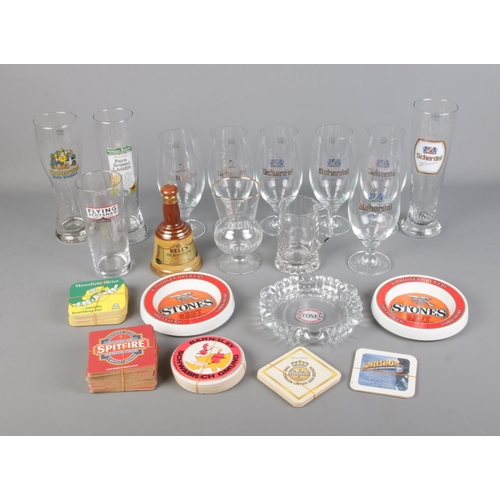 142 - A collection of breweriana to include glassware, beer mats, Bell's Whisky bell decanter, etc.