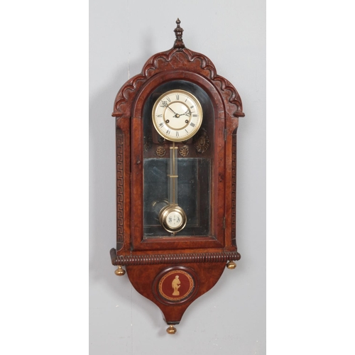 222 - A mahogany and walnut cased wall clock, with carved arched top and 'Greek Key' column detailing. Fea... 