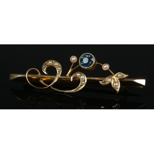 272 - A 9ct gold bar brooch set with aquamarine and seed pearls in floral mounts. Total weight 2.2g.