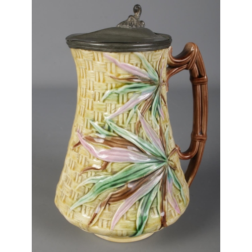 79 - A Victorian majolica jug with pewter lid. Mark dated 1876 to the base. (20cm)