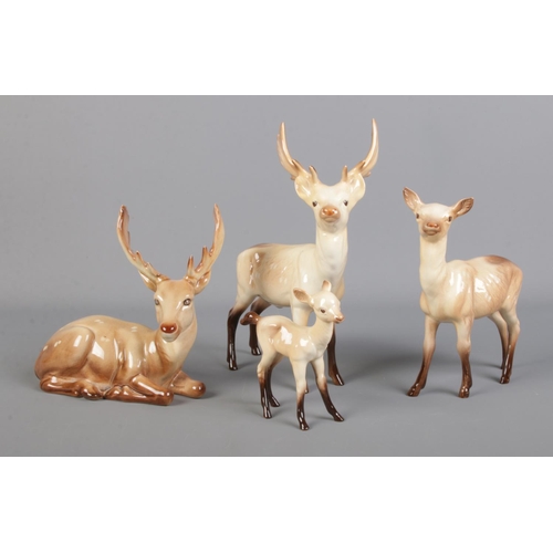 298 - A family of four Beswick deers, to include sitting adult (954) and fawn.