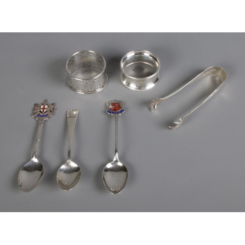 307 - A collection of silver to include two napkin rings, three souvenir spoons and pair of sugar tongs. H... 