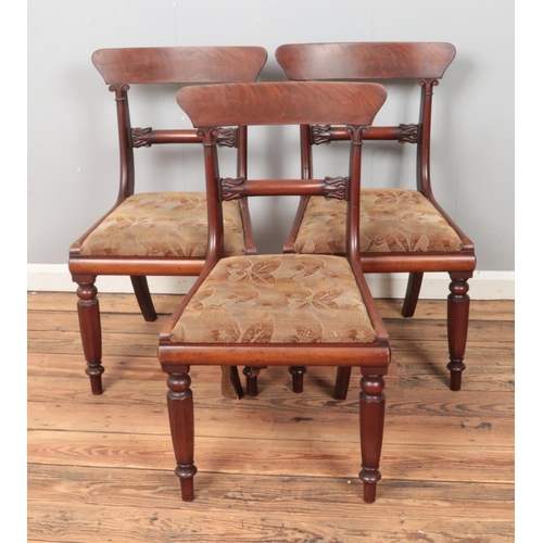 313 - Three Victorian mahogany dining chairs featuring floral upholstered seats.